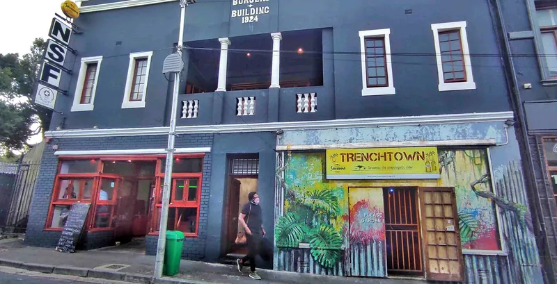 Trenchtown's building on Lower Main Road, with jungle murals and a yellow Trenchtown sign