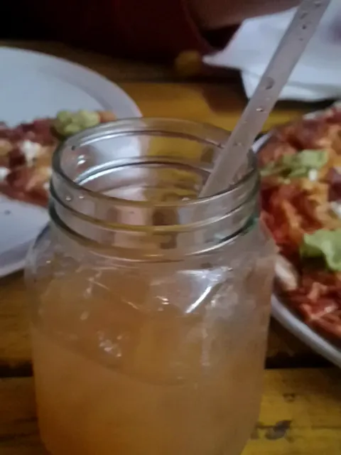 An amber jam-jar cocktail with a straw