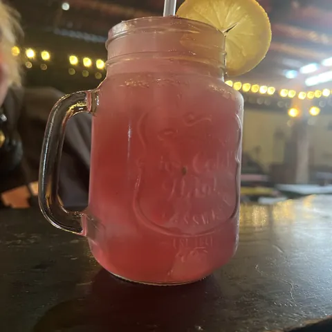 A pink jam-jar cocktail with a lemon slice at Trenchtown